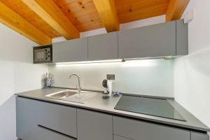 a kitchen with white cabinets and a sink at Appartamenti Suly 3 - Cir0084 in Saint Vincent