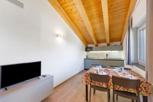 a dining room with a table with chairs and a flat screen tv at Appartamenti Suly 3 - Cir0084 in Saint Vincent