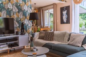 a living room with a couch and a tv at Domaine S&B in Aubenas