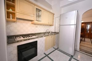 a kitchen with a white refrigerator and a sink at Casa Rita in Gonnosfanàdiga