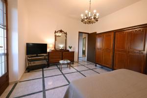 a bedroom with a bed and a tv and a mirror at Casa Rita in Gonnosfanàdiga