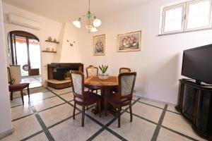 a dining room with a table and chairs and a tv at Casa Rita in Gonnosfanàdiga +8 photos