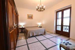 a bedroom with a bed and a chandelier at Casa Rita in Gonnosfanàdiga