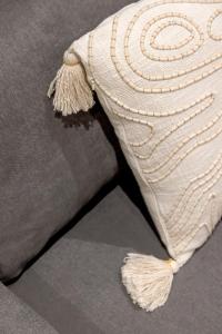 a pair of white pants with tassels on a pillow at CapeTown Marula 1BR apartment in Caparica