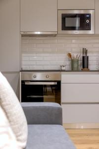 a kitchen with a stove and a microwave at CapeTown Marula 1BR apartment in Caparica