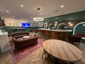 a bar with couches and a table in a room at Logis Hotel Restaurant La Marjolaine in Moulay