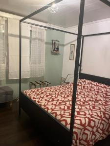 a bedroom with a bed with a red comforter at APPARTEMENT CONLEAU VANNES avec JARDIN PARTAGE in Vannes