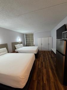 a hotel room with two beds and a refrigerator at Noble Suites in Albany