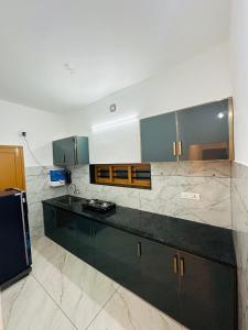 a kitchen with green cabinets and marble counter tops at Castle villa in Cochin