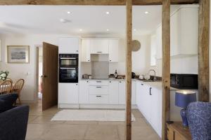 a kitchen with white cabinets and white appliances at Norton Subedge Barn in Mickleton