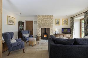 a living room with a couch and chairs and a fireplace at Norton Subedge Barn in Mickleton