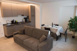 a living room with a couch and a table and a kitchen at Suite Prestige Apartment in Torri del Benaco +6 photos