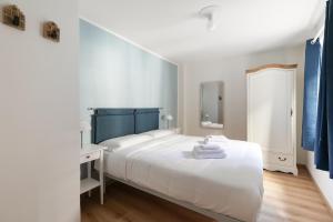 a bedroom with a white bed and a blue headboard at Casa Lidia in Villaretto