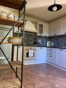 a kitchen with white cabinets and an oven at Ancient townhouse next castle in Vezzano Ligure