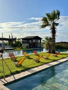 a group of chairs sitting next to a swimming pool at Meezane Farmhouse in Bir Jedíd Saint-Hubert
