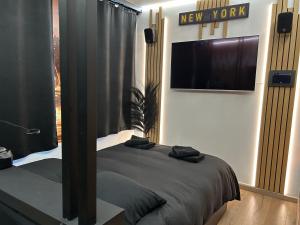 a bedroom with a bed and a television on the wall at Maison 3 chambres, jacuzzi, billard, sauna, air soccer, clim in Verviers