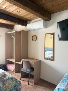 a bedroom with a desk and a tv and a bed at Affittacamere Castelmanardo in Amandola