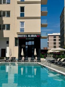 a hotel with a swimming pool in front of a building at Hotel Iliria in Golem