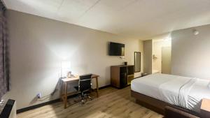a hotel room with a bed and a desk with a computer at Studio 6 Suites Fremont, OH in Fremont