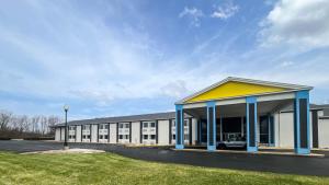 a large building with a yellow and blue roof at Studio 6 Suites Fremont, OH in Fremont