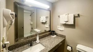 a bathroom with a sink and a mirror and towels at Studio 6 Suites Fremont, OH in Fremont +39 photos
