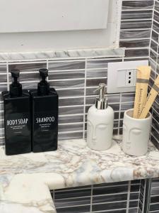 a shelf with three bottles of soap and a timer at Sa Costixedda Rooms in Cagliari