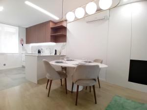 a dining room with a table and chairs and a kitchen at Da Valeta Ó in Arcos de Valdevez