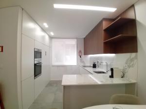 a white kitchen with a sink and a stove at Da Valeta Ó in Arcos de Valdevez