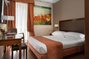 a hotel room with a bed and a desk and a desk at Grand Hotel Adriatico in Florence