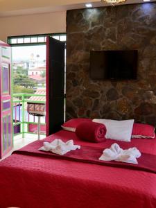 a bedroom with a red bed with towels on it at Rincon del descanso in Salento