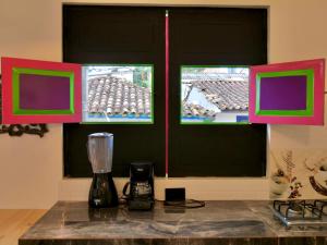 a kitchen with two windows and a blender on a counter at Rincon del descanso in Salento