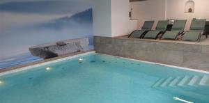 a swimming pool in a building with chairs around it at Hotel Schiff am Schluchsee in Schluchsee