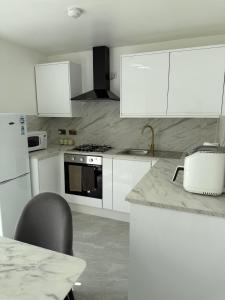 a kitchen with white cabinets and a counter top at The cumbria place in Elswick