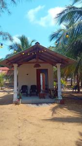 a house on the beach with a wooden pergola at Cocos cabana in Ilandaiyadi