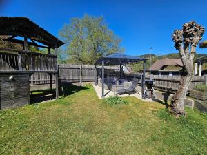 a gazebo and a chair in a yard at Ankommen und loswandern Familien und Hundeurlaub im Hochschwarzwald Ferienwohnung Haus Maria in St. Blasien