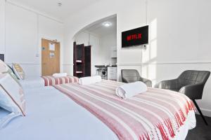 a bedroom with two beds and a tv on the wall at Modern Self-Contained Studio in Dudley Sleeps 2 in Dudley +1 photo