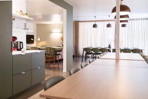 a kitchen and dining room with a long table and chairs at Het Kasterhuis - Groepsverblijf in Wetteren