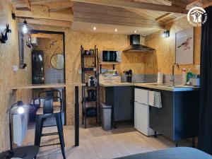 a kitchen with a counter and a bar with a stool at La cachette du G in Bellebrune