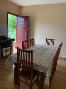a dining room with a table and chairs and a window at Casa Por Do Sol in Paraty