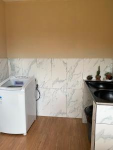 a kitchen with white marble tiles on the wall at Casa Por Do Sol in Paraty +13 photos