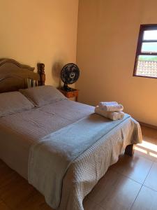 a bedroom with a bed with a blanket and a window at Casa Por Do Sol in Paraty