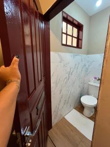 a person taking a picture of a bathroom with a toilet at Casa Por Do Sol in Paraty