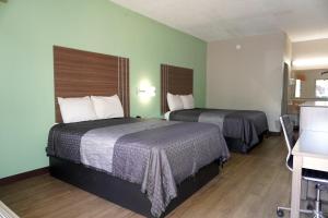 two beds in a hotel room with green walls at Fairview Inn & Suites Mobile in Mobile +12 photos