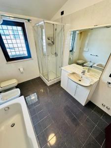 a bathroom with a shower and a sink and a tub at Mamisà 4 - appartamenti e camere private con bagno in Schio