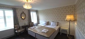 a bedroom with a bed with two towels on it at Svaneholm Hotel in Svanskog