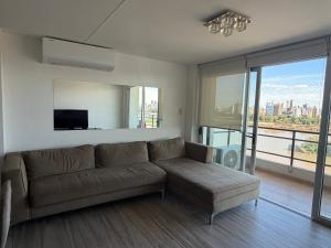 a living room with a couch and a flat screen tv at Puerto Amarras Apartment in Santa Fe