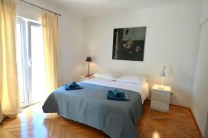 a bedroom with a bed with two blue towels on it at Adriatic Breeze in Hvar