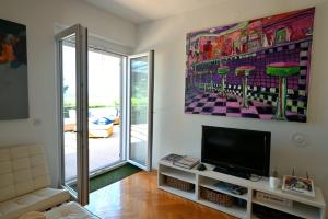 a living room with a tv and a large painting on the wall at Adriatic Breeze in Hvar