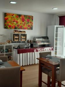a restaurant with a counter with a table with chairs at Hotel Santa Apolonia in Bragança