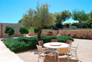 a white table and chairs in a garden at Luxury Villa Son Mas in Manacor
